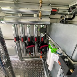 Eine technische Anordnung von Rohren und Pumpen in einem modernen Raum, die für die Wasser- oder Luftversorgung genutzt wird.