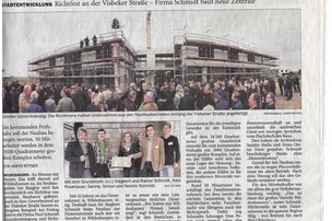 Eine große Menschenmenge versammelt sich vor einem Bauprojekt in Wildeshausen, während die Richtkrone gefeiert wird.