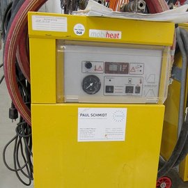 Ein gelbes Heizgerät mit einem Bedienfeld, das verschiedene Schalter und Anzeigen zeigt, steht in einer Werkstatt.