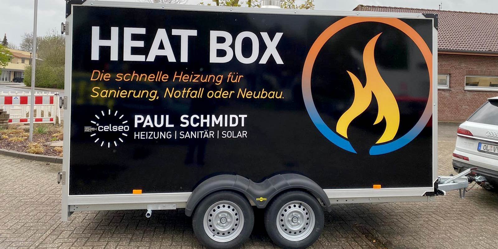 Ein Anhänger mit der Aufschrift 'HEAT BOX', der schnelle Heizlösungen für Notfälle und Neubauten anbietet.